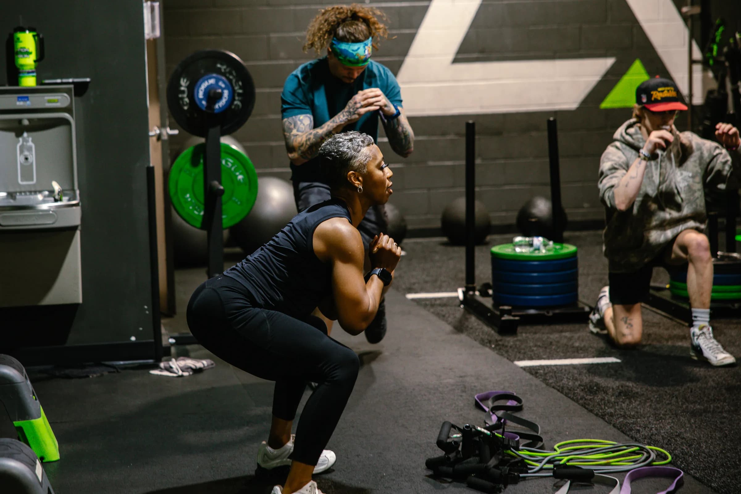 A coach helping an athlete with a goblet squat