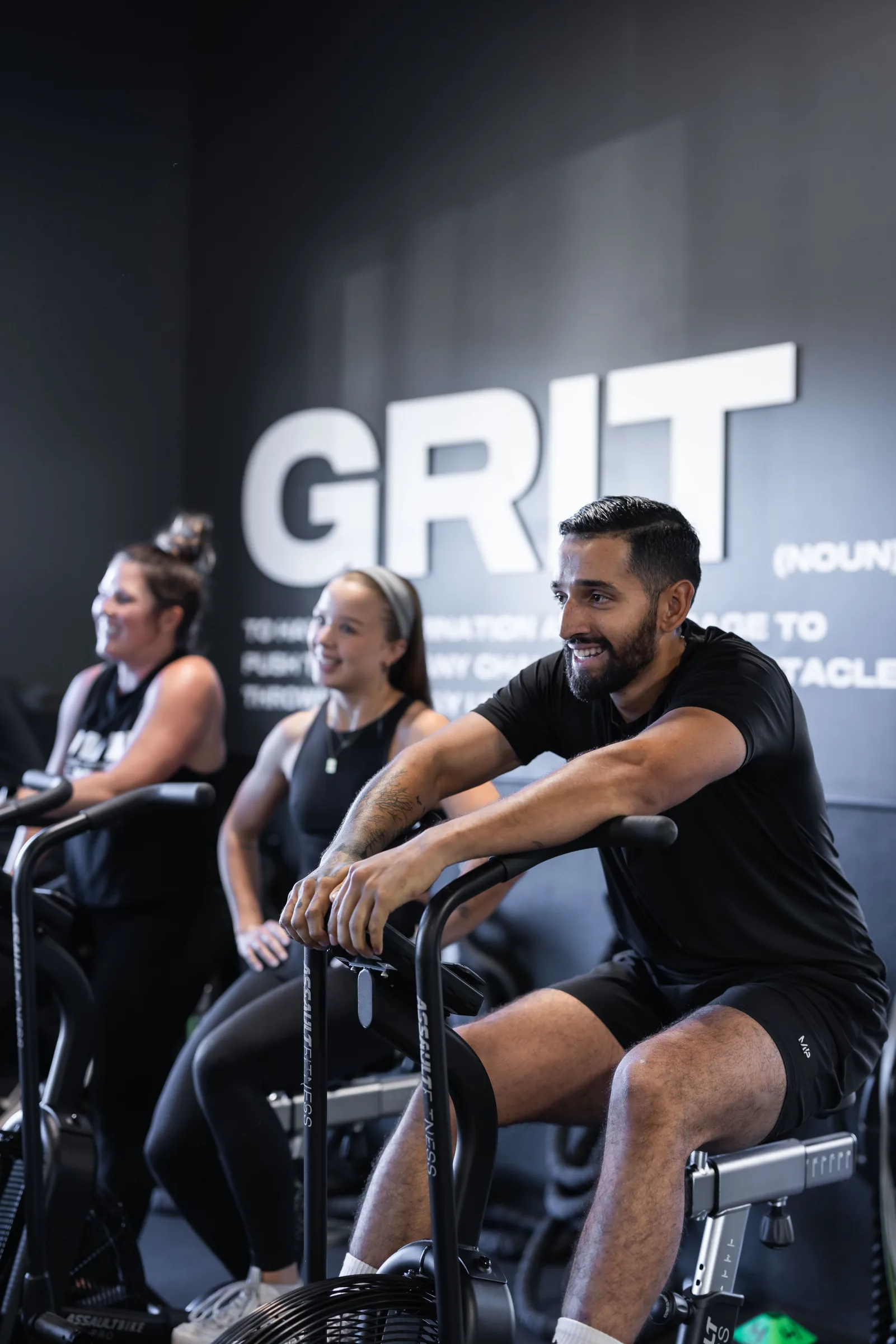 Athletes working through a coached air-bike session